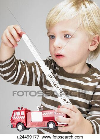 Stock Photo - Little boy playing with fire truck. . Fotosearch
