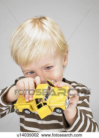 Stock Image - Little boy playing with yellow truck.. Fotosearch