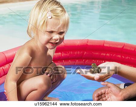 Little girl looking at a frog. View Large Photo Image Picture - Little girl looking at a frog.. Fotosearch