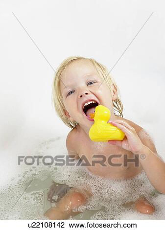Stock Image - Little girl taking a bath yellow duck.. Fotosearch