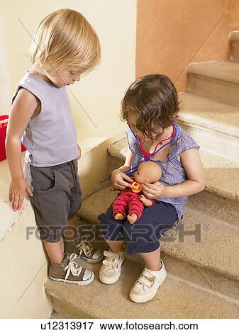 Little girls playing doctor with doll. View Large Photo Image Stock Photo - Little girls playing doctor with doll.. Fotosearch