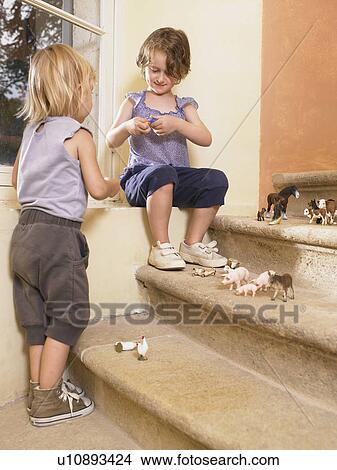 Picture - Little girls with plastic animals.. Fotosearch