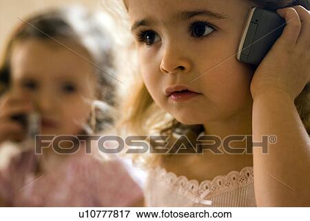 Two girls (2-4) using mobile phone. View Large Photo Image Stock Photo - Two girls (2-4) using mobile phone.. Fotosearch