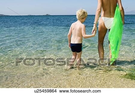 Woman holding inflatable raft with young boy on the beach. View Large Photo Image Picture - Woman holding inflatable raft with young boy on the beach.. Fotosearch