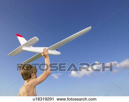Stock Image - Young boy ready to send off an airplane.. Fotosearch