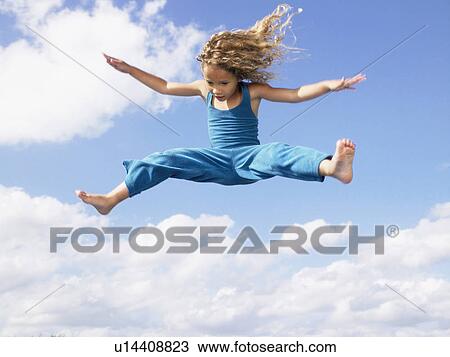 Stock Image - Young girl jumping in the air.. Fotosearch