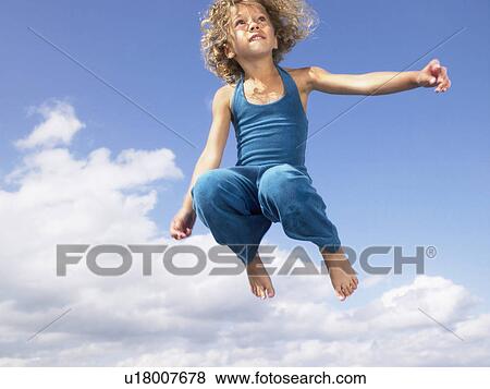 Stock Photo - Young girl jumping in the air.. Fotosearch