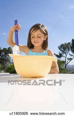 Young girl stirring cream in a bowl. View Large Photo Image Stock Photograph - Young girl stirring cream in a bowl.. Fotosearch