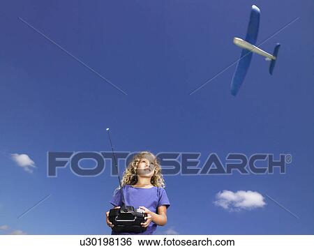 Stock Photograph - Young girl with remote-control.. Fotosearch