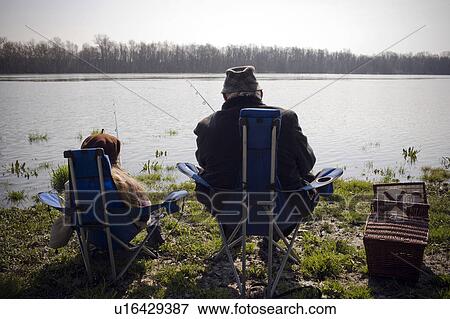 Grandfather and granddaughter (10-12) fishing by river, rear view View Large Photo Image Stock Photo - Grandfather and granddaughter (10-12) fishing by river, rear view. Fotosearch