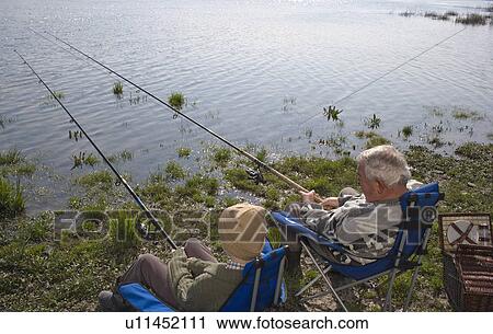 Grandfather and grandson (12-14) fishing by river, rear view View Large Photo Image Stock Image - Grandfather and grandson (12-14) fishing by river, rear view. Fotosearch