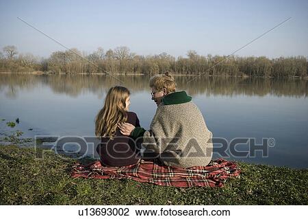Grandmother and granddaughter (10-12) sitting by river, rear view View Large Photo Image Stock Image - Grandmother and granddaughter (10-12) sitting by river, rear view. Fotosearch
