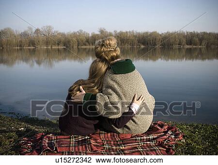 Grandmother and granddaughter (10-12) sitting by river, rear view View Large Photo Image Stock Image - Grandmother and granddaughter (10-12) sitting by river, rear view. Fotosearch