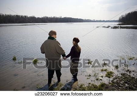 Grandmother and granddaughter (10-12) standing in river, rear view View Large Photo Image Stock Photo - Grandmother and granddaughter (10-12) standing in river, rear view. Fotosearch