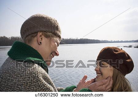 Grandmother holding hands up to granddaughter's (10-12) face, smiling View Large Photo Image Stock Image - Grandmother holding hands up to granddaughter's (10-12) face, smiling. Fotosearch