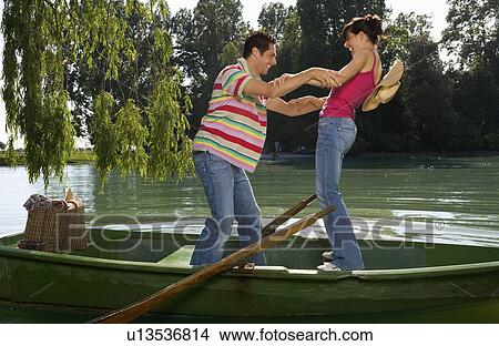 Picture - Man and woman balancing on boat. Fotosearch