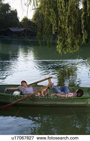 Stock Photo - Man and woman lying down in a boat. Fotosearch