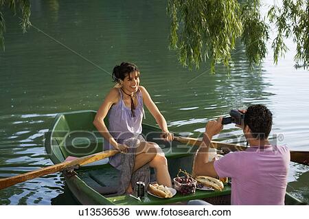 Man filming a woman on boat View Large Photo Image Stock Photograph - Man filming a woman on boat. Fotosearch