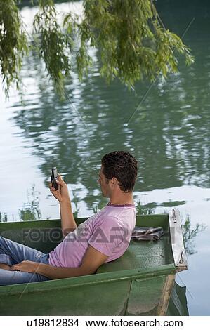 Man using a cell phone on boat View Large Photo Image Picture - Man using a cell phone on boat. Fotosearch