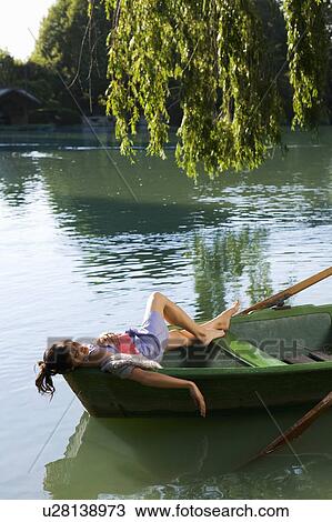Woman lying down in a boat View Large Photo Image Stock Image - Woman lying down in a boat. Fotosearch
