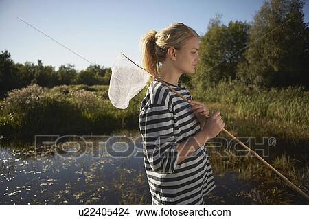 Young Woman by pond with fishing net. View Large Photo Image Picture - Young Woman by pond with fishing net.. Fotosearch