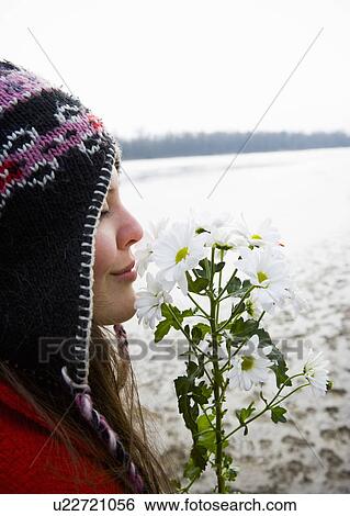Young woman outdoors smelling flowers, eyes closed, close-up View Large Photo Image Stock Photograph - Young woman outdoors smelling flowers, eyes closed, close-up. Fotosearch