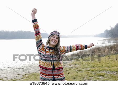 Young woman outdoors, stretching arms, smiling, portrait View Large Photo Image Stock Photography - Young woman outdoors, stretching arms, smiling, portrait. Fotosearch