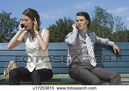 Businessman and women talking on cell phones while sitting on bench outside. View Large Photo Image Stock Photography - Businessman and women talking on cell phones while sitting on bench outside.. Fotosearch