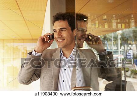 Man talking on his cell phone in a doorway. View Large Photo Image Stock Image - Man talking on his cell phone in a doorway.. Fotosearch