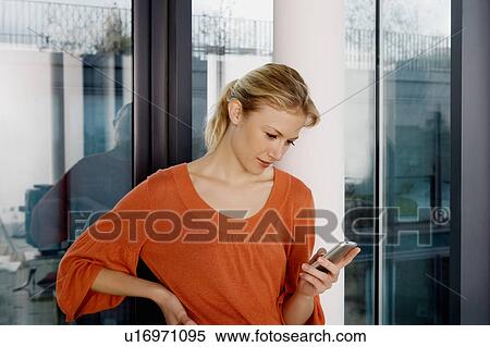 Stock Photography - Portrait of a woman using an iphone.. Fotosearch