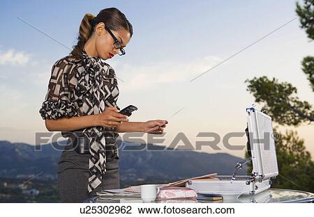 Stock Image - Woman working at home outdoors.. Fotosearch