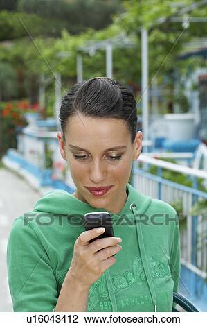 Young woman looking at cell phone. View Large Photo Image Stock Image - Young woman looking at cell phone.. Fotosearch