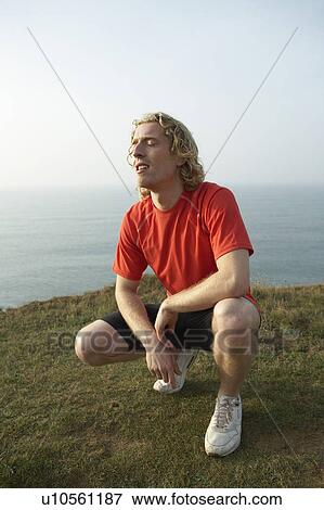 Stock Photo - A Male runner crouches.. Fotosearch
