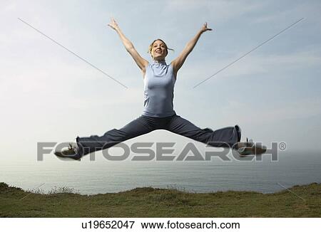 Stock Photo - A Woman leaping into the air.. Fotosearch