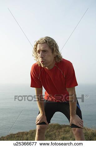 A young Male runner catches his breath. View Large Photo Image Stock Photo - A young Male runner catches his breath.. Fotosearch