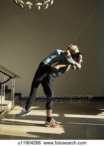 Man helping woman stretch back, side view View Large Photo Image Stock Photograph - Man helping woman stretch back, side view. Fotosearch