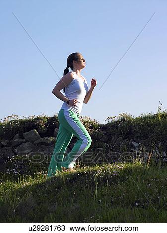 Woman jogging up a hill. View Large Photo Image Stock Image - Woman jogging up a hill.. Fotosearch