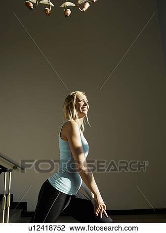 Stock Image - Woman stretching by steps, side view. Fotosearch