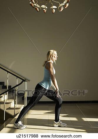 Stock Photo - Woman stretching by steps, side view. Fotosearch