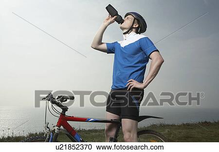 A male cyclist drinks. View Large Photo Image Stock Image - A male cyclist drinks.. Fotosearch