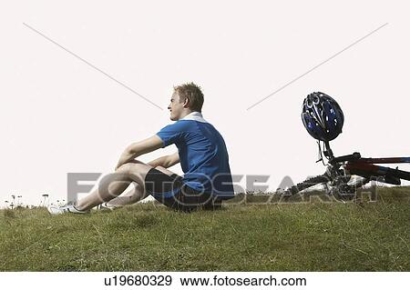 A male cyclist rests on a mountain path. View Large Photo Image Stock Photo - A male cyclist rests on a mountain path.. Fotosearch