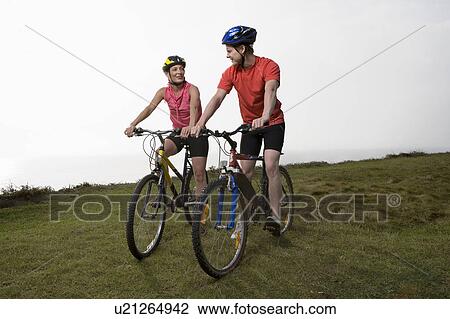 Man and Woman cycling on a cliff path. View Large Photo Image Stock Image - Man and Woman cycling on a cliff path.. Fotosearch