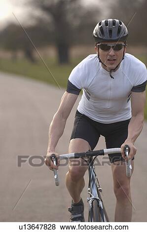 Stock Photo - Man cycling in park. Fotosearch