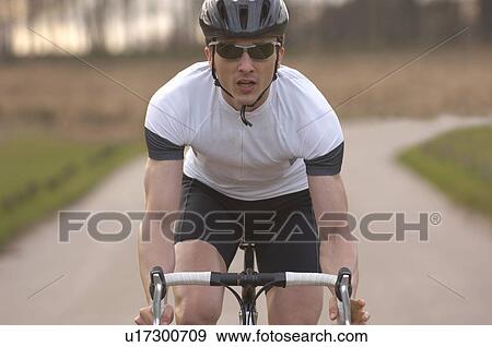 Stock Photo - Man cycling in park. Fotosearch