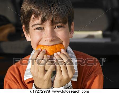 Boy (8-10) eating orange, close-up, portrait View Large Photo Image Stock Photo - Boy (8-10) eating orange, close-up, portrait. Fotosearch