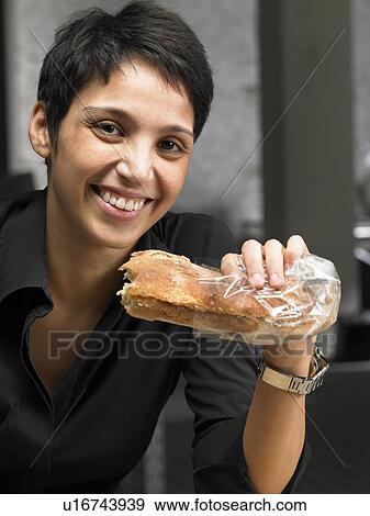 Stock Photo - Businesswoman having a snack. Brussels, Belgium.. Fotosearch