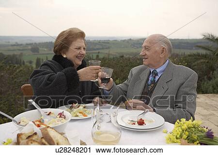 Stock Image - Senior couple toasting outdoors. Fotosearch