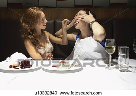 Two women in a restaurant feeding each other View Large Photo Image Stock Image - Two women in a restaurant feeding each other. Fotosearch
