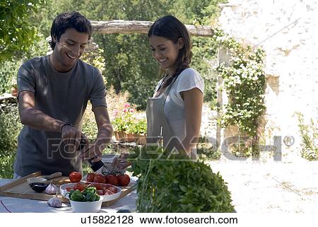 Young couple cooking together View Large Photo Image Stock Photo - Young couple cooking together . Fotosearch