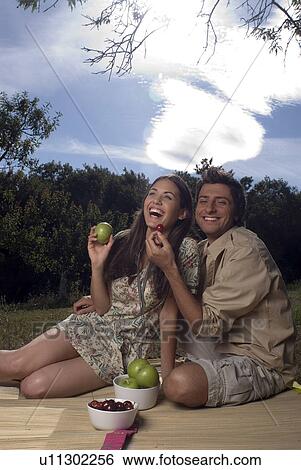 Young couple sharing fresh fruit View Large Photo Image Stock Photograph - Young couple sharing fresh fruit . Fotosearch